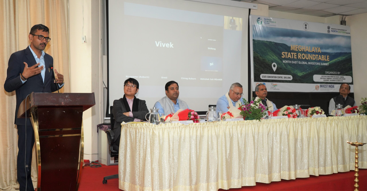 Officials and investors seated at the Meghalaya State Roundtable banner for the North East Global Investors Summit